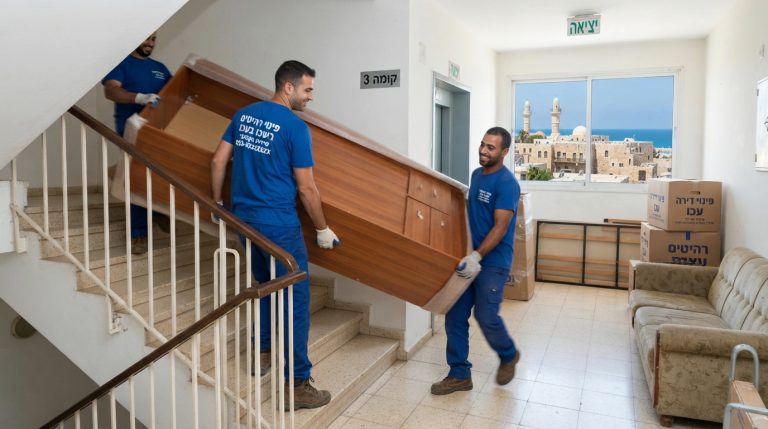 צוות מקצועי של חברת פינוי דירות מפנה רהיטים ישנים וספה מבית בעכו אל משאית פינוי ברחוב.