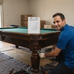 שולחן משחק גדול ומאסיבי בשלבי מדידה והכנה לפינוי, הממחיש את החשיבות של בדיקת מידות וגישה לפני הזמנת שירות פינוי.