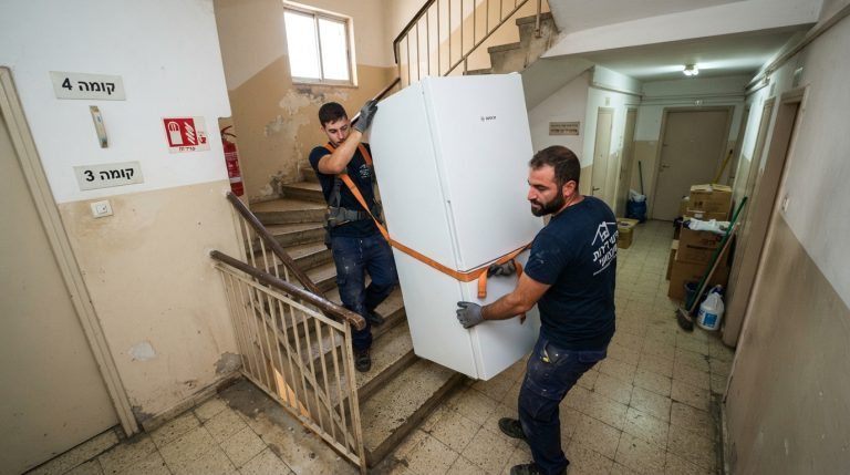 שני מובילים מקצועיים מחברת פינוי דירות נושאים בזהירות מקרר כבד במורד חדר מדרגות צר בבניין מגורים ללא מעלית
